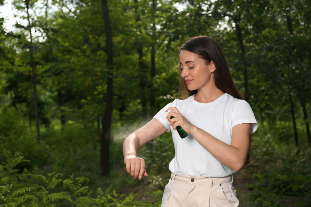 A woman using one of the best natural mosquito repellents